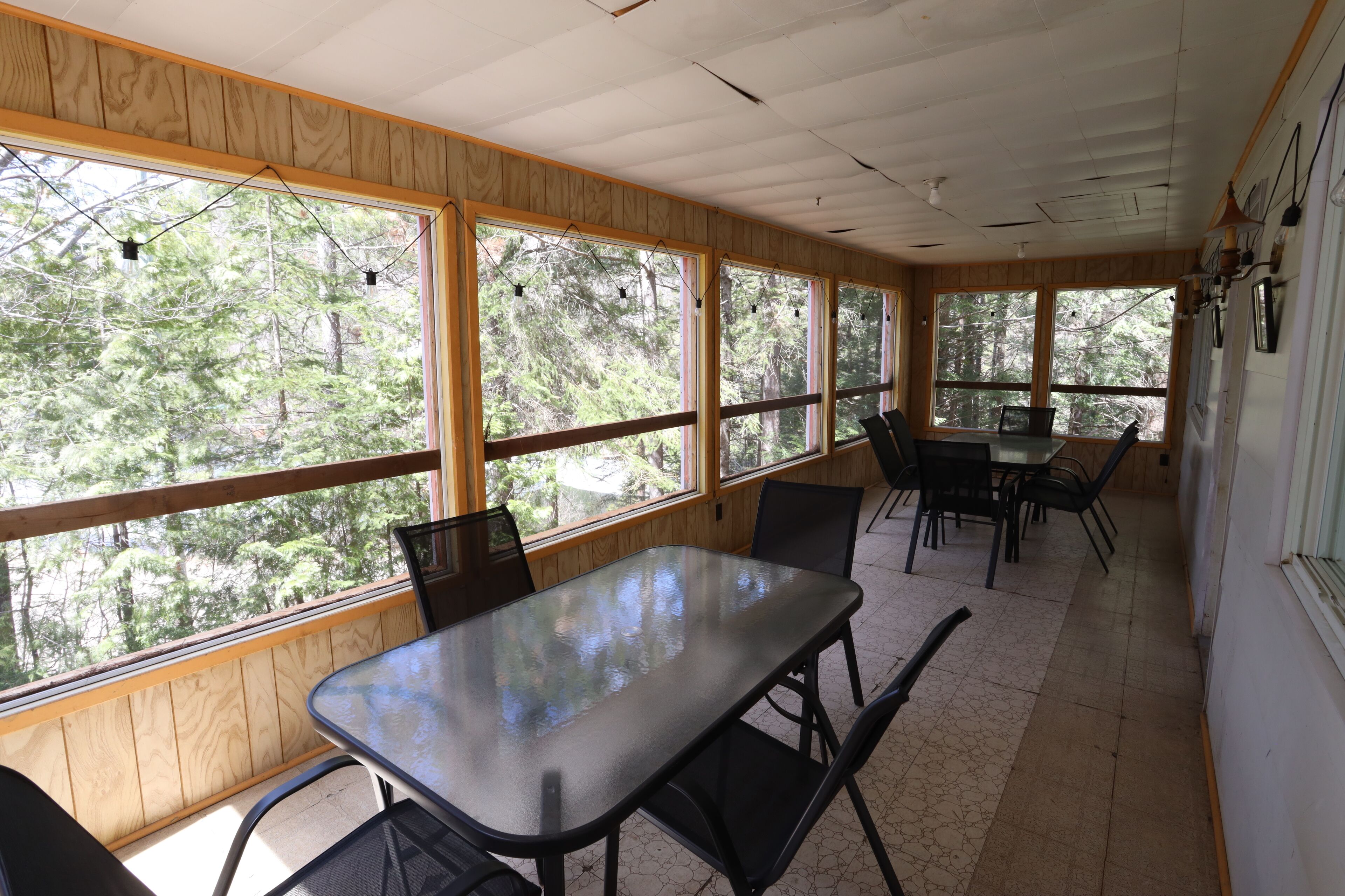 A room with large windows, a table, and chairs.