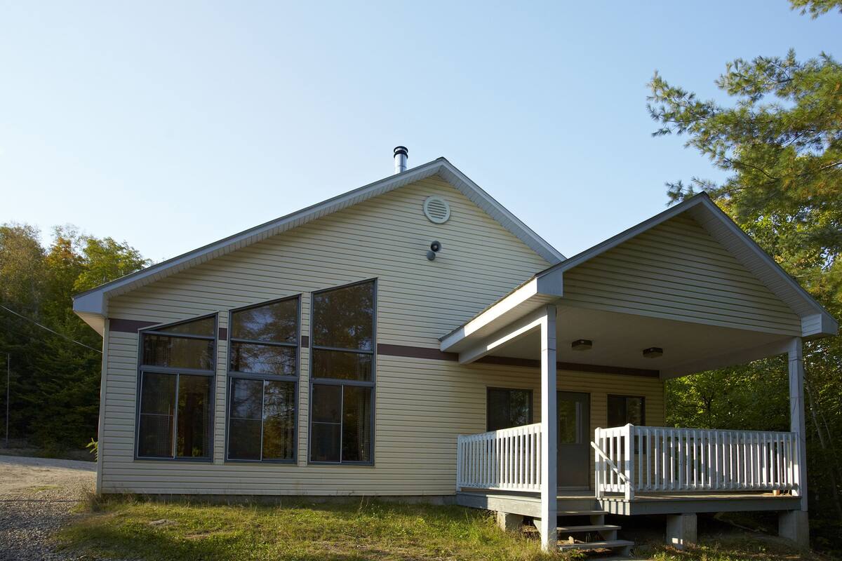 A single-story house with a porch and large windows.