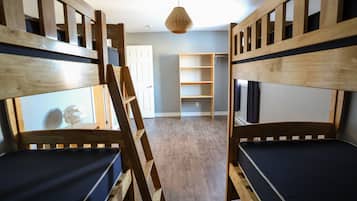 Una habitación con literas, una escalera y una lámpara colgante.
