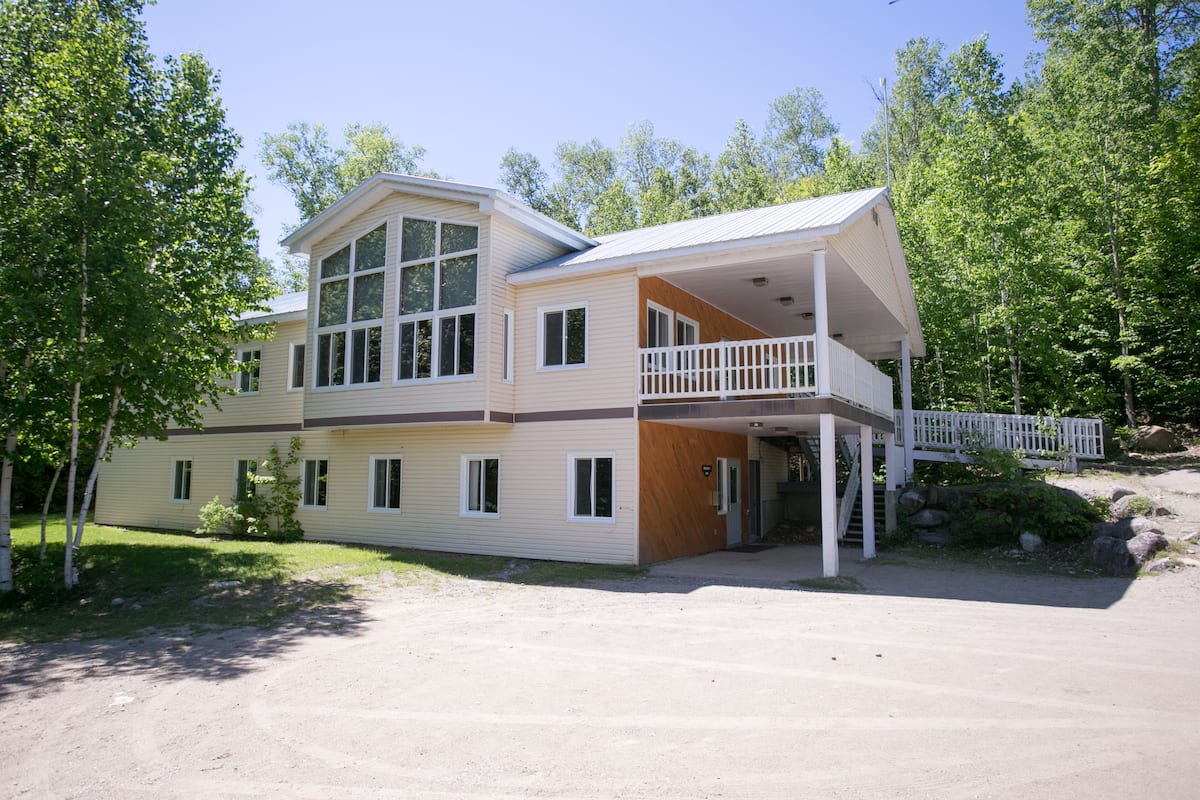 A two-story house with a balcony, a covered porch, and a driveway.