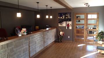 A reception area with a stone counter, pendant lighting, and a wooden ceiling.