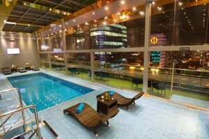 Una piscina techada, sillones reclinables de piscina