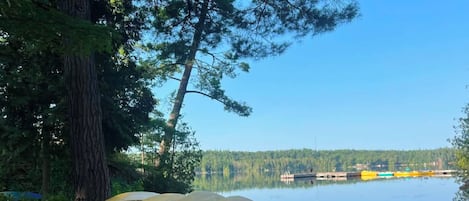 Puinen piknikpöytä, jonka päällä on valkoinen muki ja sen ympärillä keltaisia tuoleja.