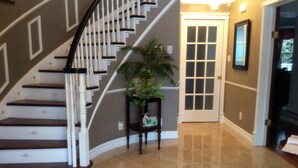 A staircase with a white railing and dark steps, leading to a door with a glass panel. - The Boston 'T' B&B (Ottawa)