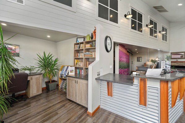 A spacious kitchen with a central island, wooden cabinets, and a built-in bookshelf.