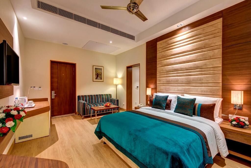 Une chambre d’hôtel comprenant un lit, un bureau, un canapé et un espace réception.