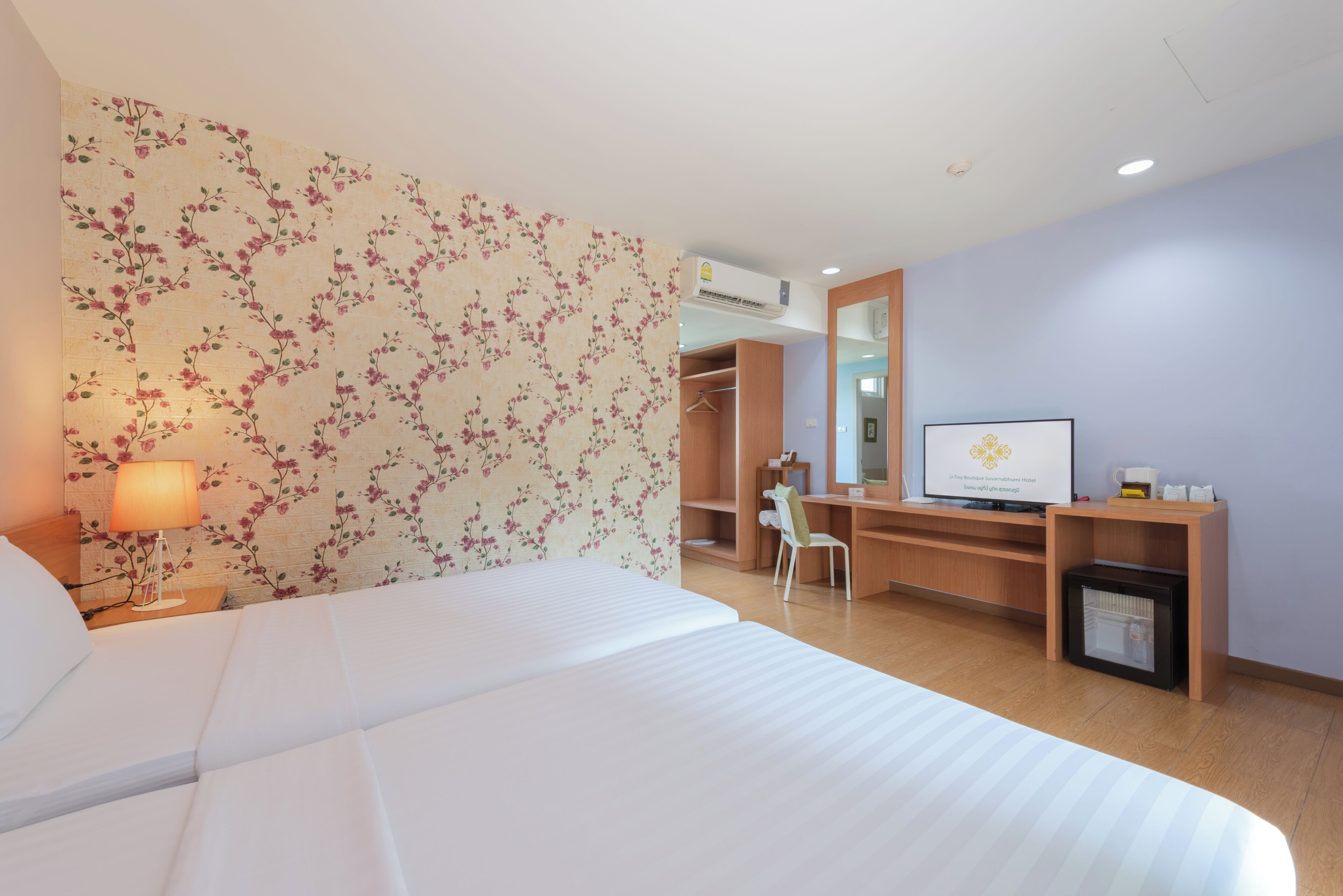 A hotel room with a bed, a desk, a chair, a TV, and a wardrobe.