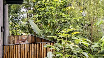 A bamboo fence with a small outdoor seating area.