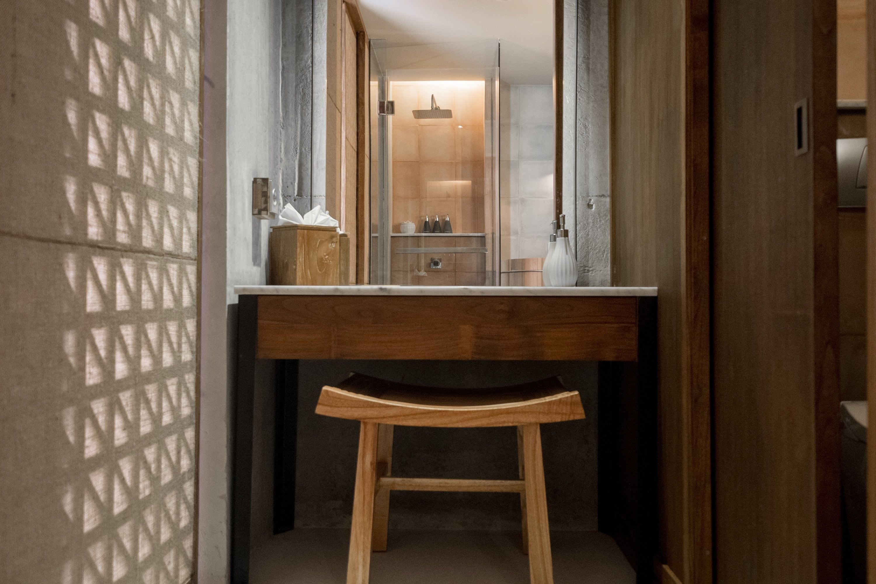 A bathroom with a wooden vanity, a towel rack, and a glass shower enclosure.
