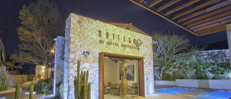Un edificio de piedra con un letrero que dice "Bottega by Hotel Boutique".
