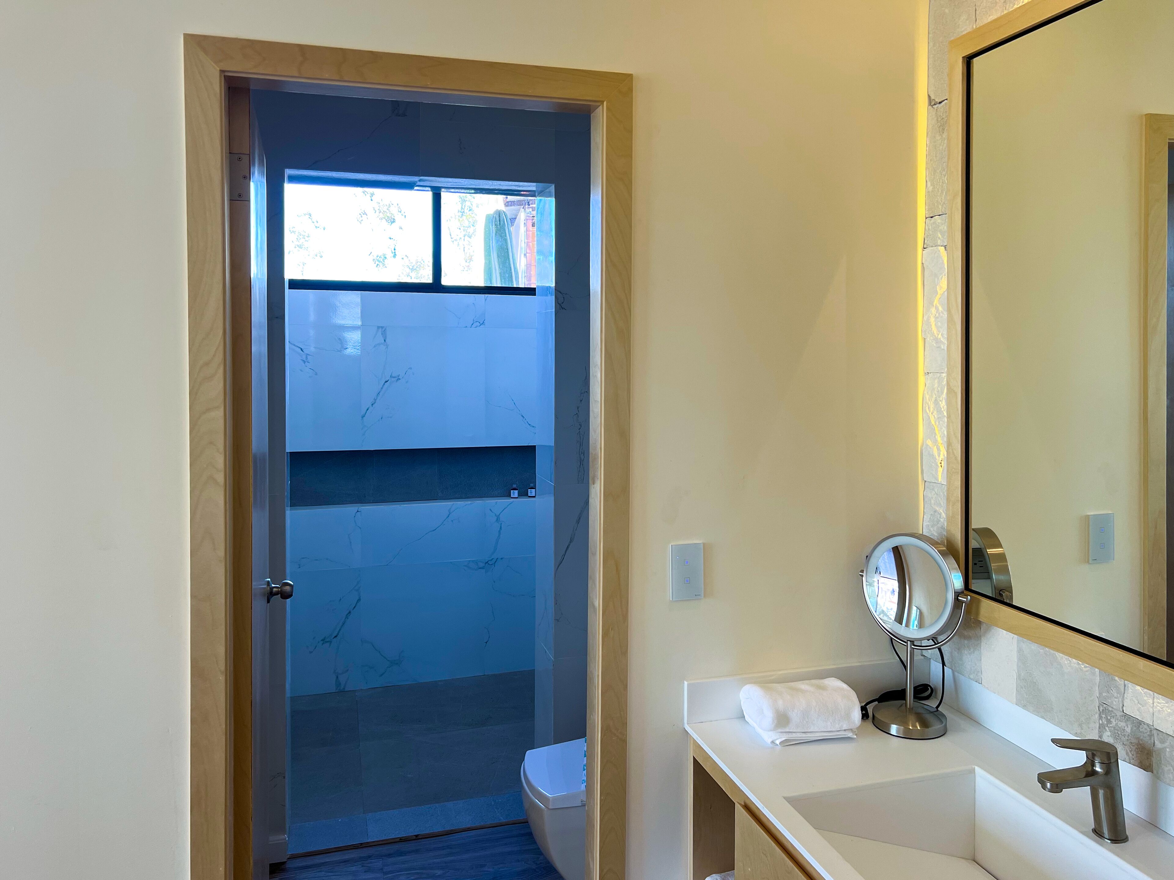 A bathroom with a marble vanity, a sink, a mirror, and a towel.