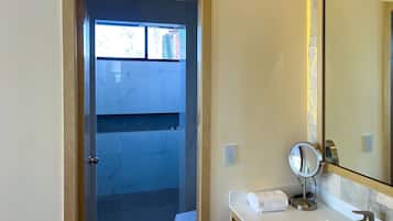 A bathroom with a marble vanity, a sink, a mirror, and a towel.