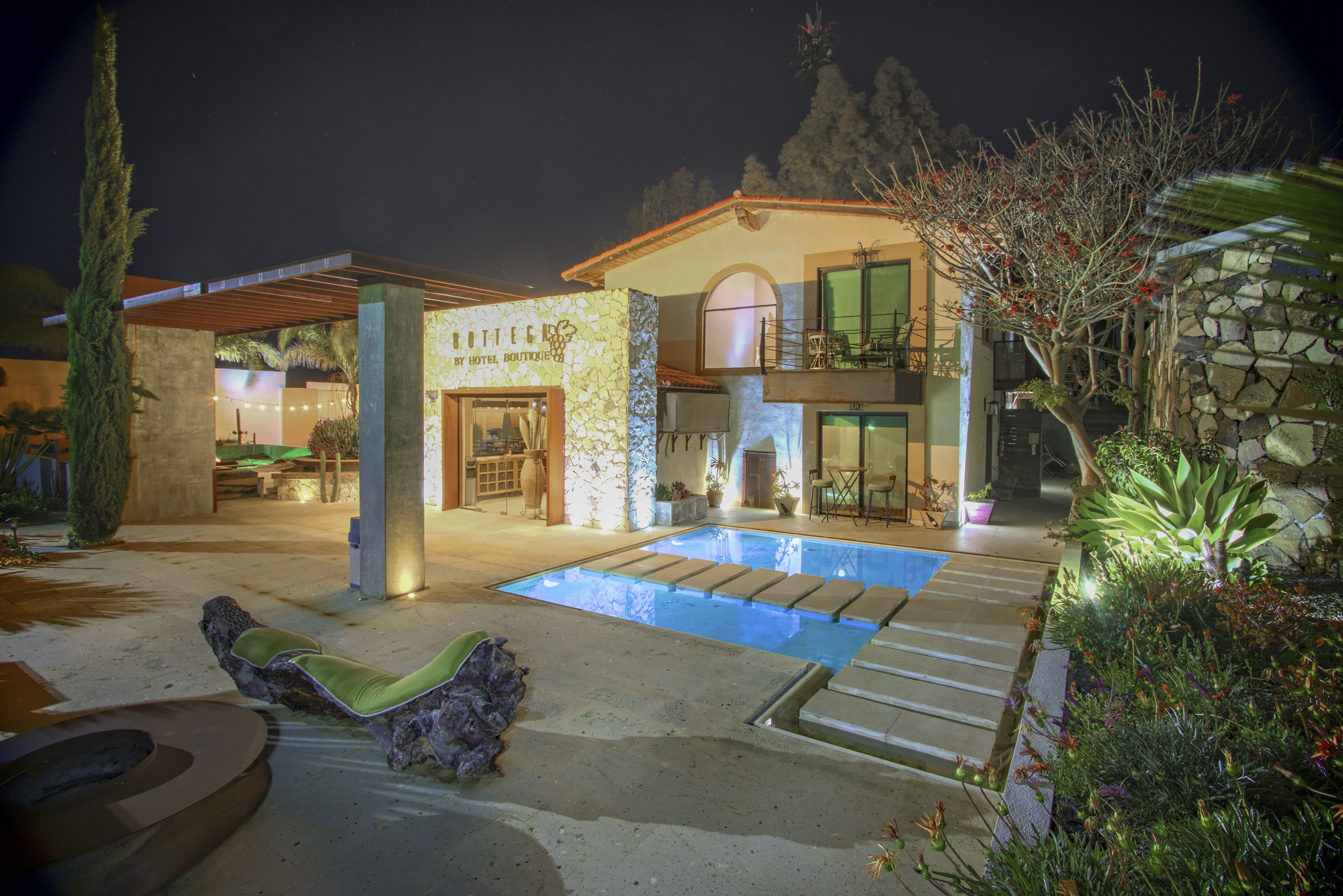 A house with a swimming pool, stone walls, and outdoor seating.