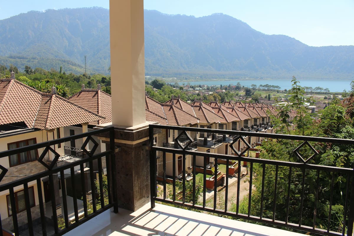 A balcony with a view of a mountainous landscape and a lake.