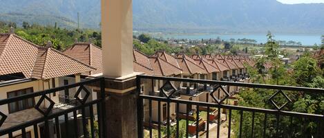 A balcony with a view of a mountainous landscape and a lake.