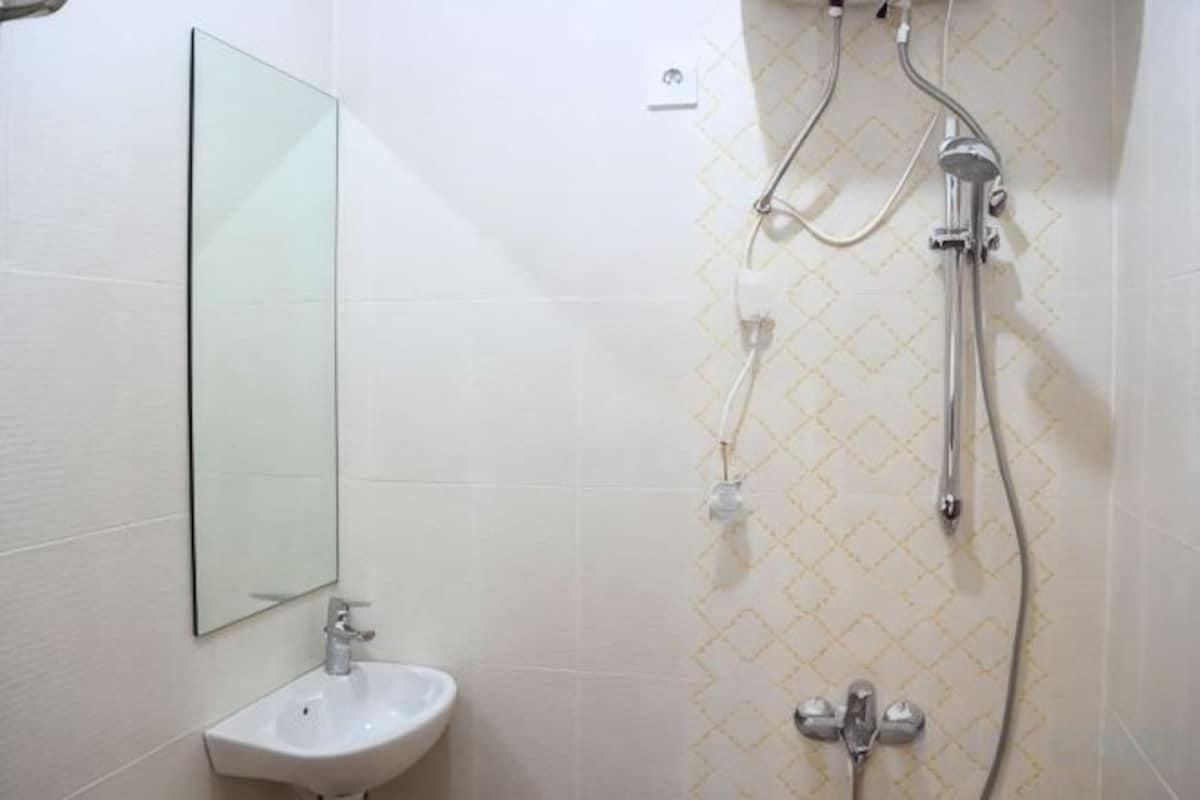 A bathroom with a sink, mirror, and shower.