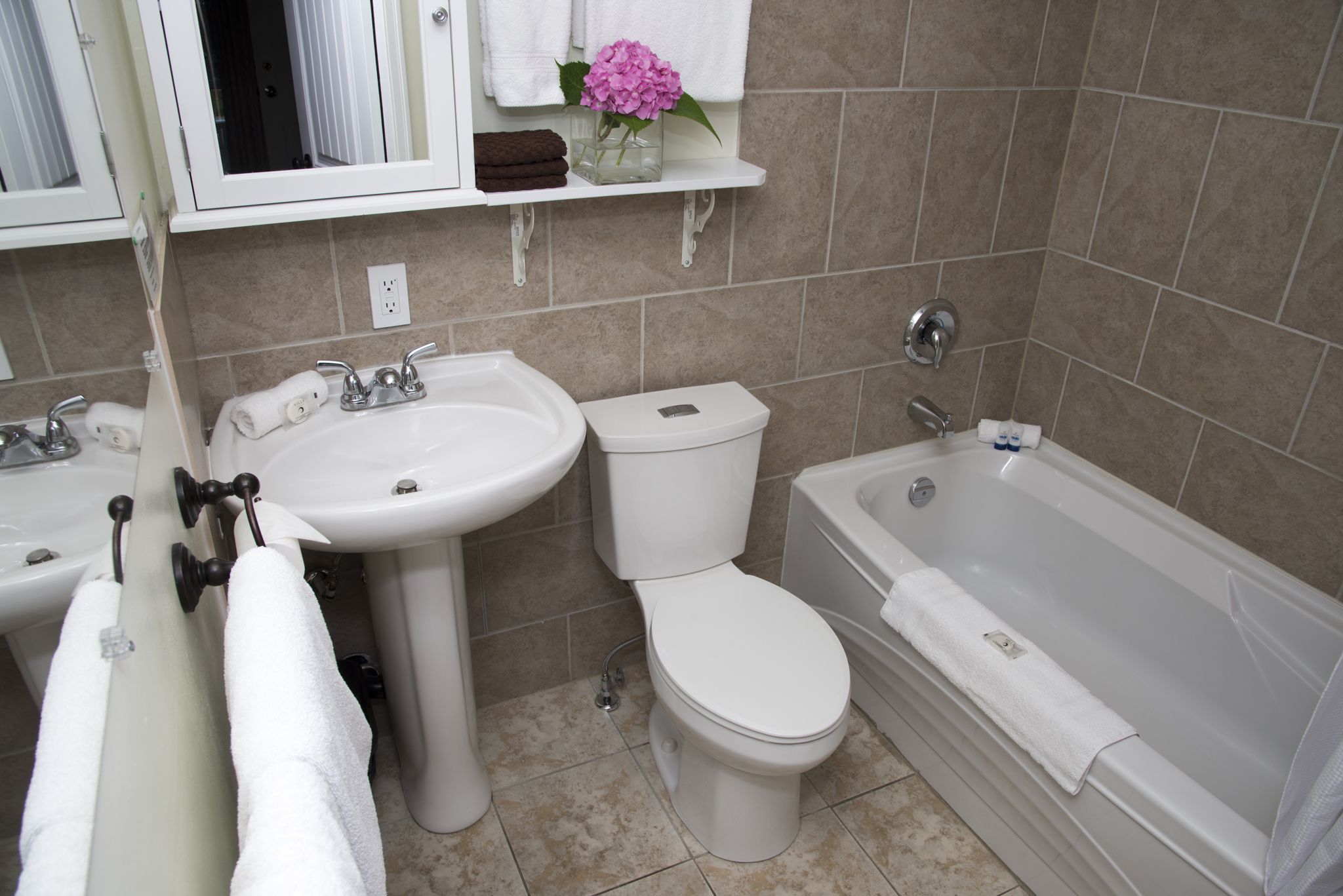 Un baño con lavamanos, inodoro y bañera.