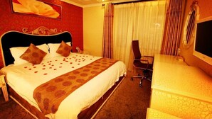 Een hotelkamer met een groot bed, een bureau en een stoel.