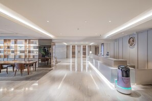 A hotel reception area with a modern design, a reception desk, and a self-service kiosk. - JI Hotel (Beijing 798 Art District) (Beijing)