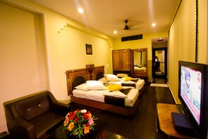 A hotel room with a bed, a TV, a desk, and a chair. - Hotel Rishi Regency (Jabalpur)