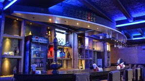 A bar area with a Pepsi refrigerator, shelves with bottles, and a hookah. - Hotel Rishi Regency (Jabalpur)