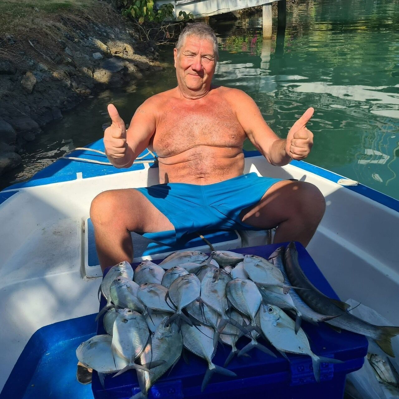 Un hombre en un bote con una red llena de peces.