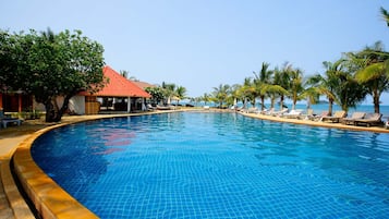 Una piscina al aire libre, sombrillas, sillones reclinables de piscina