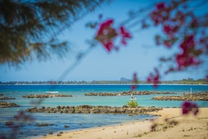 En la playa, playa de arena blanca, camastros y sombrillas