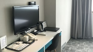 A hotel room with a desk, a television, a telephone, a coffee machine, and a trash bin. - LUMOS INN (Taipei)