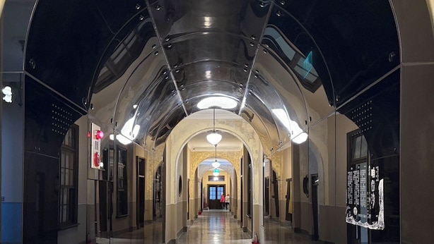 A modern, well-lit corridor with reflective surfaces and a central light fixture. - LUMOS INN (Taipei)