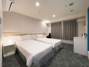 A hotel room with two beds, a desk, a chair, a small refrigerator, and a window with curtains. - LUMOS INN (Taipei)