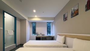 A modern hotel room with two beds, a desk, and a window with a view of trees. - LUMOS INN (Taipei)
