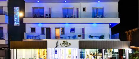 A modern hotel with a two-story structure, a visible entrance, and outdoor seating area.