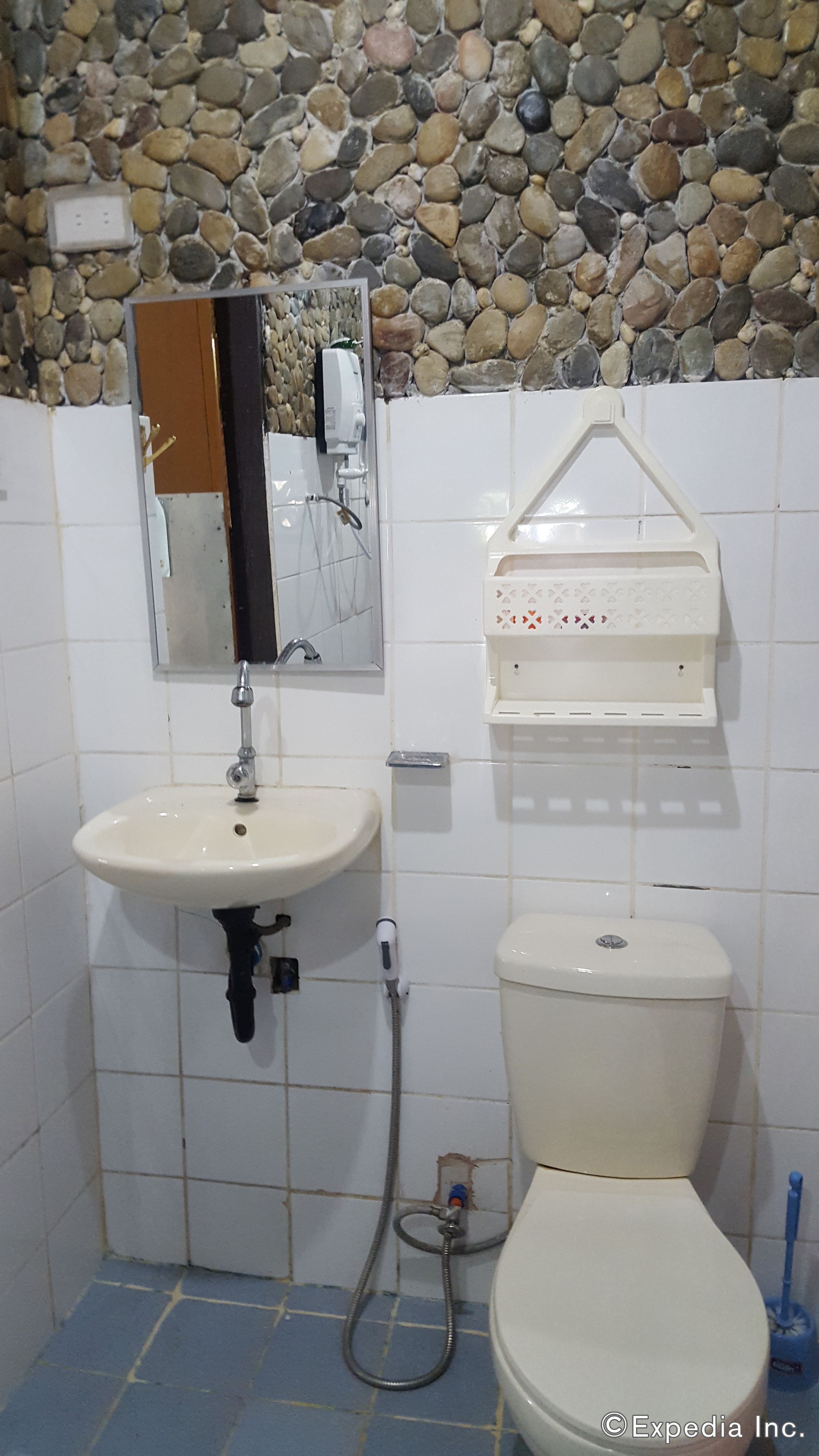 A bathroom with a sink, mirror, and toilet.
