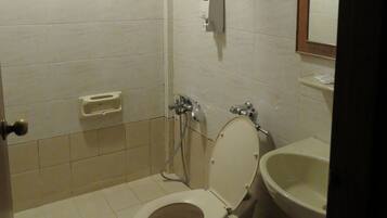 Un baño pequeño con inodoro, lavabo y ducha.