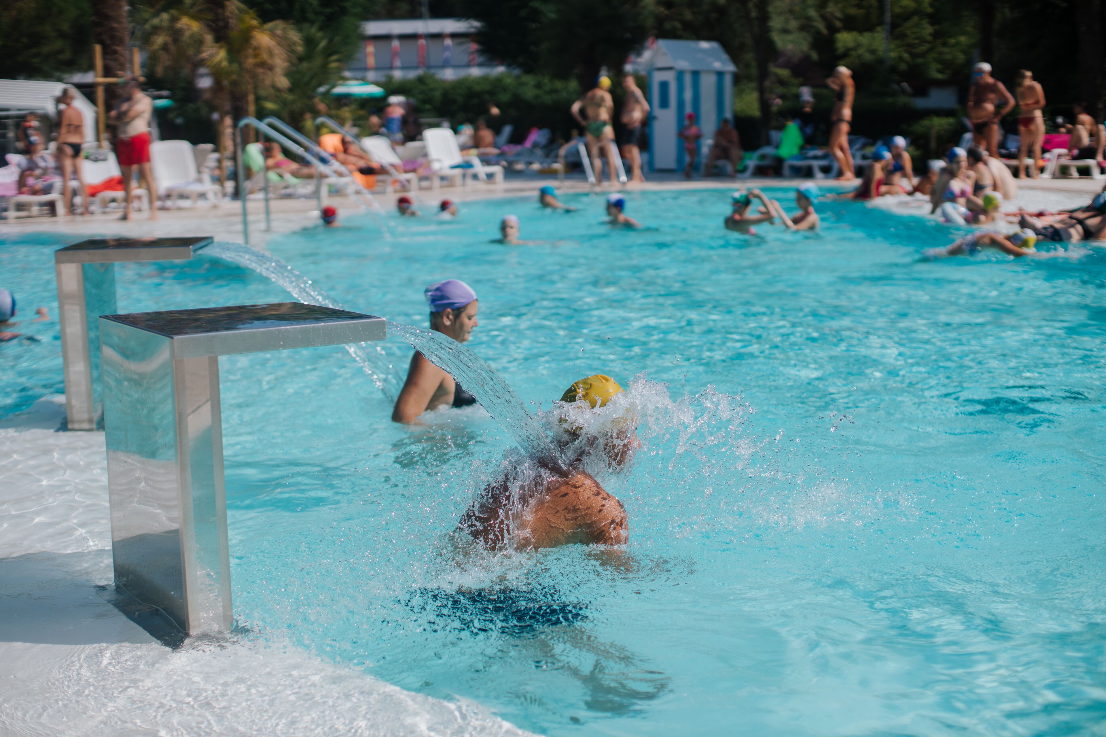 Een zwembad met mensen die watersporten beoefenen.