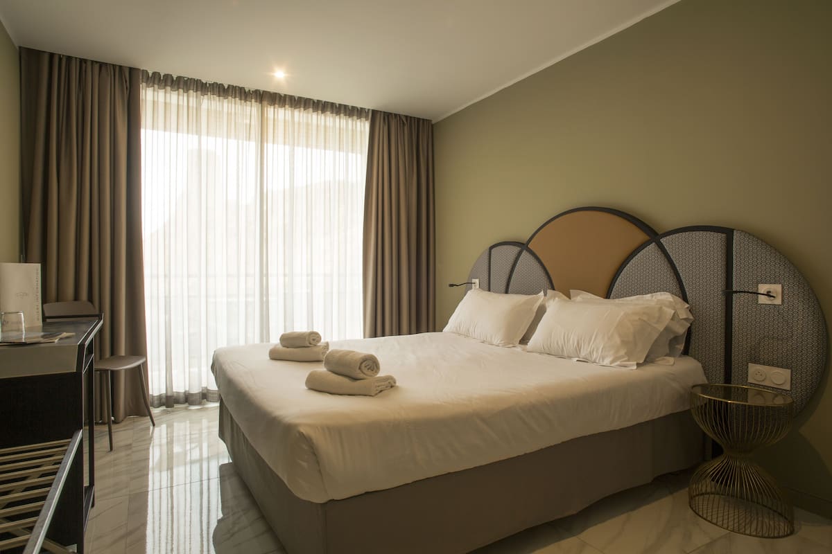 Une chambre d’hôtel avec un grand lit, un bureau et une chaise.