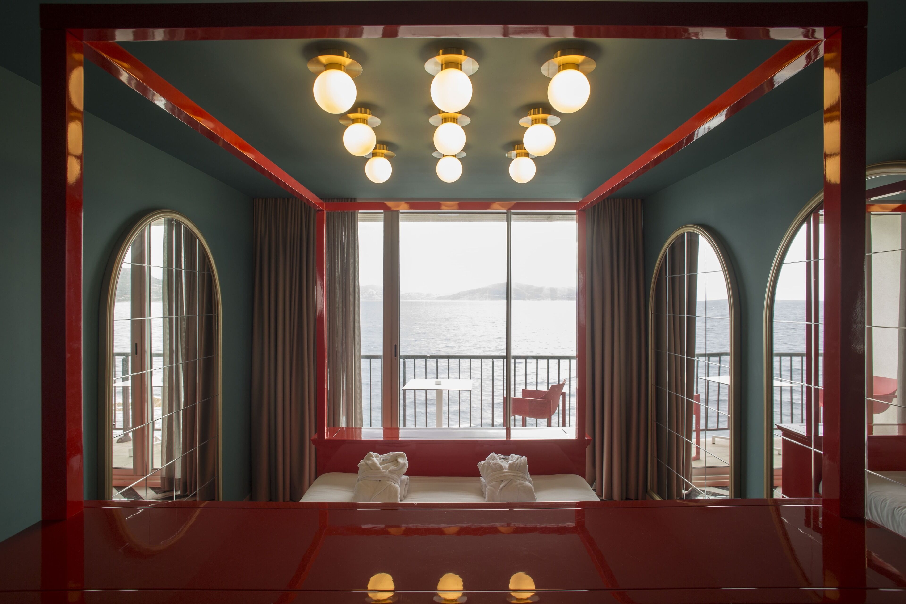 A room with a large window, a bed, and a table with towels.
