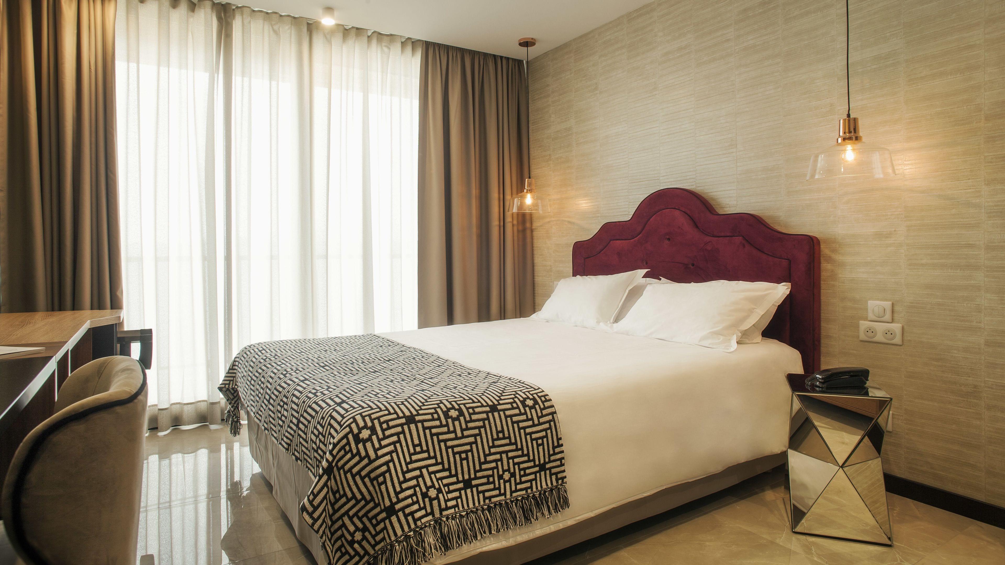 Une chambre d’hôtel avec un grand lit, un bureau et une chaise.