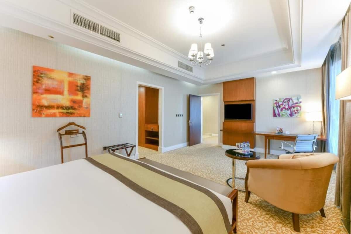 Une chambre d’hôtel comprenant un lit, une chaise, un bureau et une kitchenette.
