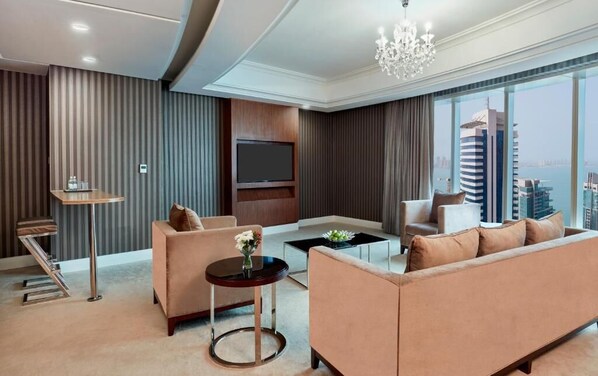 A modern living room with a sofa, a coffee table, a TV, and a view of the cityscape. - Best Plaza West Bay (Doha)