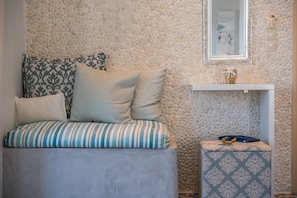 A bedroom with a bed, pillows, a bedside table, and a mirror. - Aphrodite Studios (Astypalaia)