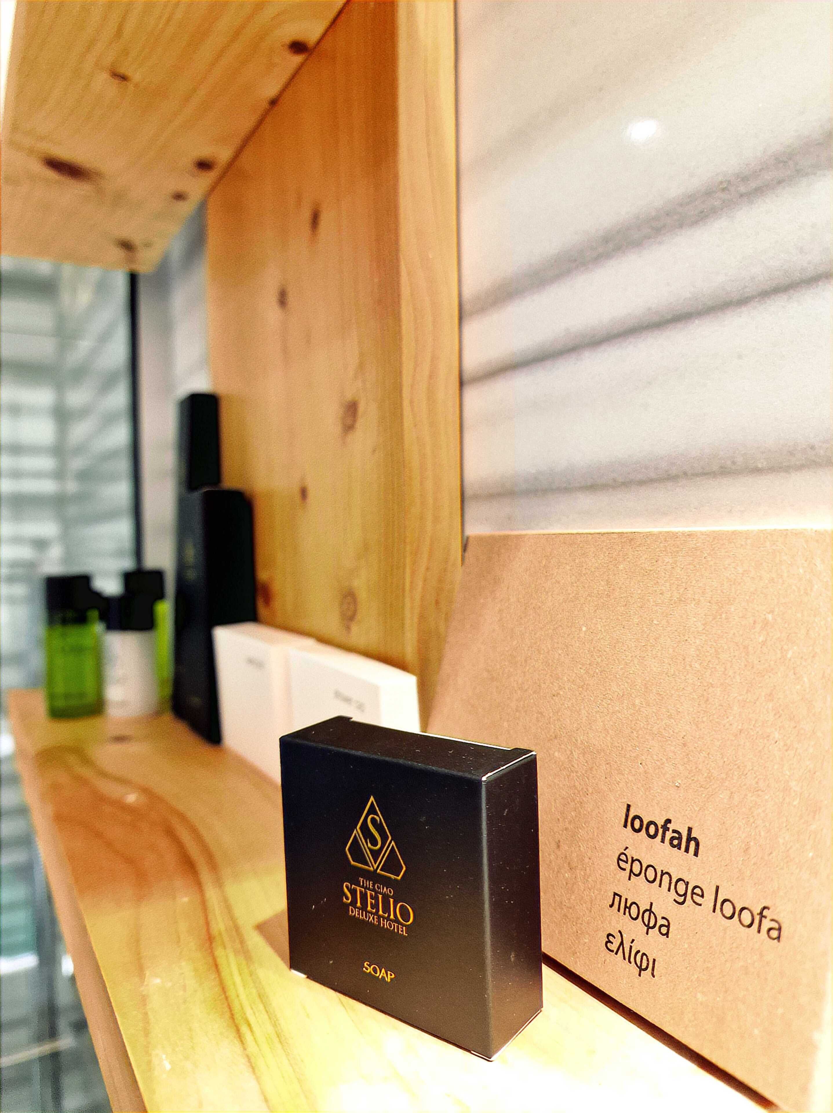 A black box labeled 'The Ciao Stelio Deluxe Hotel' soap on a wooden counter with a marble background.