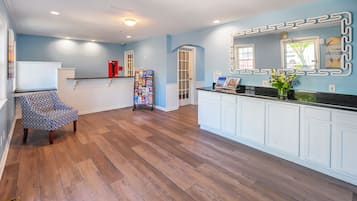 A spacious kitchen with wooden flooring, a built-in island, and a modern backsplash.