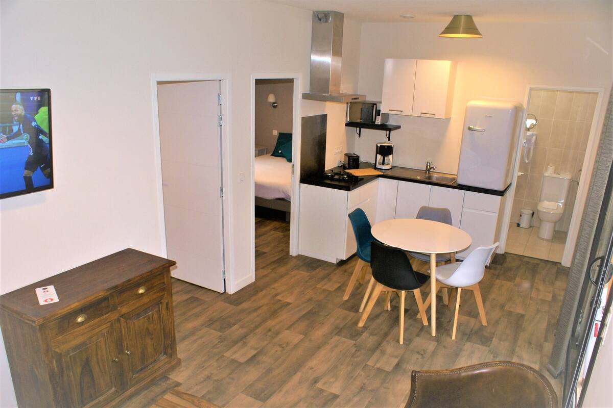 Una cocina compacta con zona de comedor, microondas, cafetera y refrigerador.