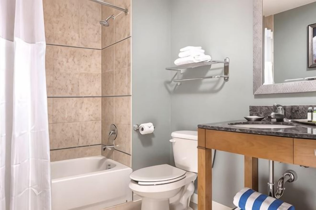 A bathroom with a bathtub, toilet, and sink.