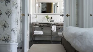 A bathroom with a white vanity, a mirror, and a towel rack. - Hotel Villa Anna (Uppsala)