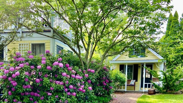 Un chemin de jardin menant à une maison dotée d’un porche.