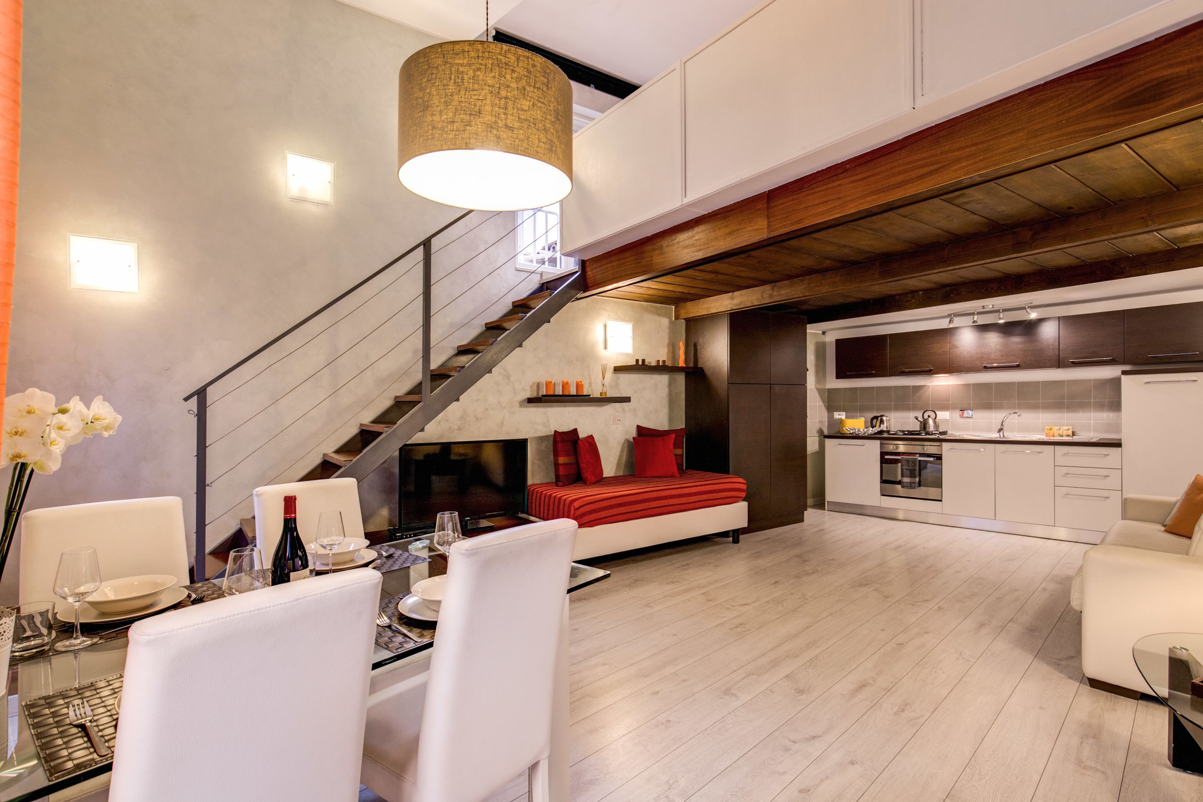 Una sala moderna con comedor, una escalera y una cocina.