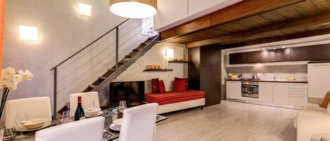Una sala moderna con comedor, una escalera y una cocina.